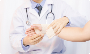 Mediķis sniedz palīdzību, apsienot traumētu roku